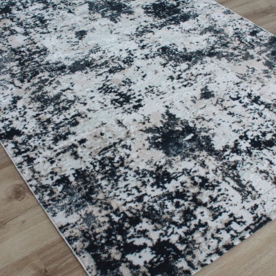 Tapete retangular abstrato cinzento preto bege sobre chão de madeira clara