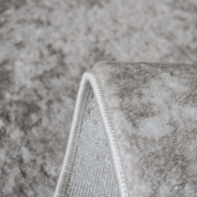 Tapete cinzento com padrão abstrato e borda costurada branca dobrado