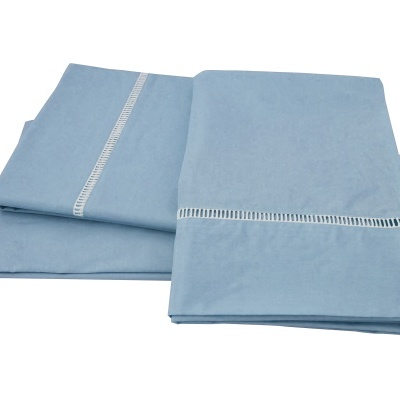 Conjunto de lençóis azul claro dobrados com bordado branco