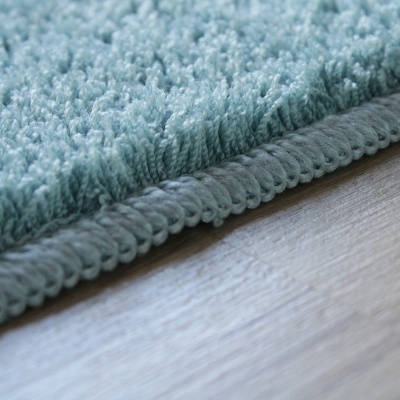 Tapete de textura esponjosa azul claro com borda rematada