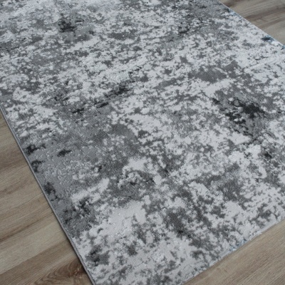 Tapete cinza e branco abstrato sobre chão de madeira