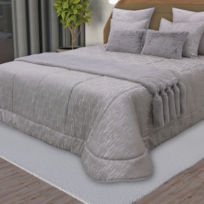 Conjunto de cama cinza claro com edredão e almofadas sobre tapete branco