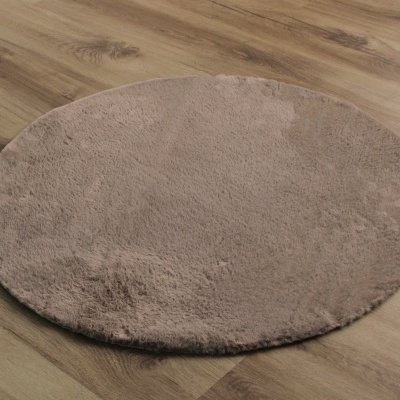 Tapete redondo castanho claro em chão de madeira