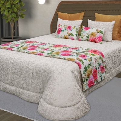 Cama com roupa de cama bege e almofadas florais