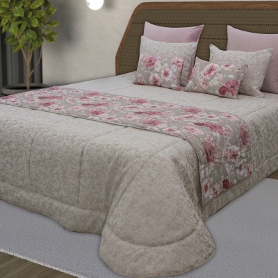 Colcha bege com padrão floral em cama de casal