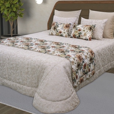 Cama com colcha bege claro e almofadas florais decorativas com motivo floral