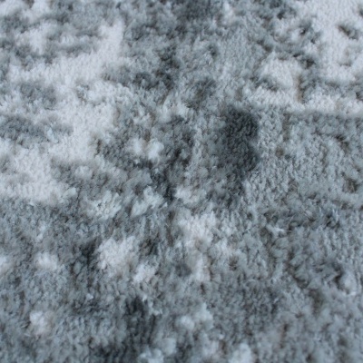 Tapete felpudo em tons de cinza e branco com padrão abstrato