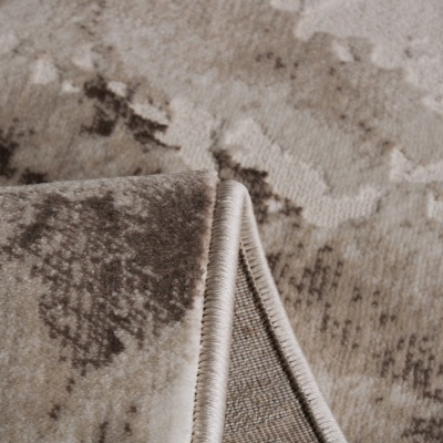Tapete com padrão abstrato bege e castanho, textura felpuda, borda enrolada.