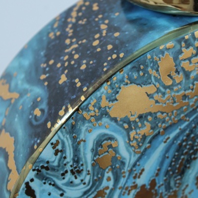 Frasco decorativo azul com padrão dourado e tampa metálica