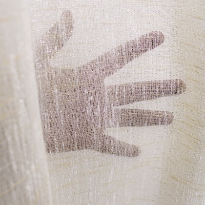 Mão por trás de tecido transparente branco com textura e brilho