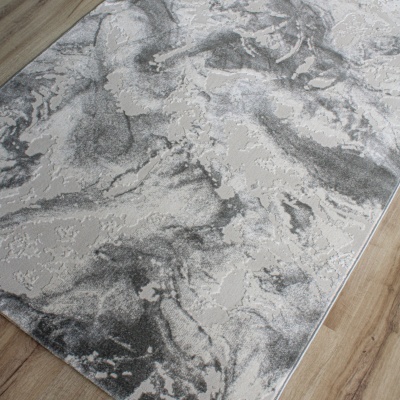 Tapete abstrato cinza e bege sobre chão de madeira