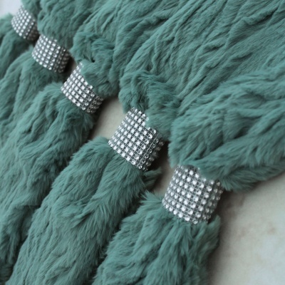 Tufos de tecido felpudo verde-azulado com argolas de strass prateadas