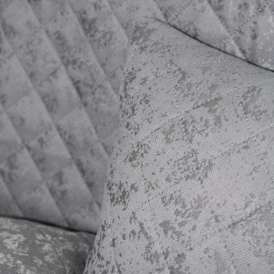 Almofada e sofá cinzentos com padrão abstrato e textura suave
