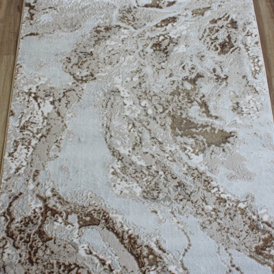 Tapete retangular bege e castanho com padrão abstrato sobre chão de madeira