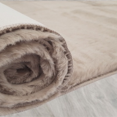 Tapete felpudo cor vison enrolado sobre piso cinza claro