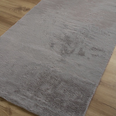 Tapete cinzento claro macio sobre chão de madeira