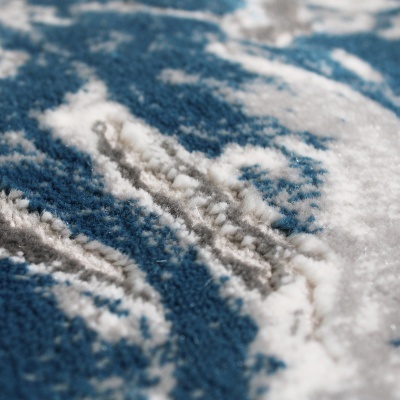 Textura detalhada de tapete azul com padrões brancos e cinza