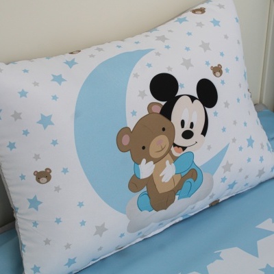 Travesseiro decorativo para cama infantil com personagem Mickey Mouse e urso abraçando sobre fundo branco com estrelas