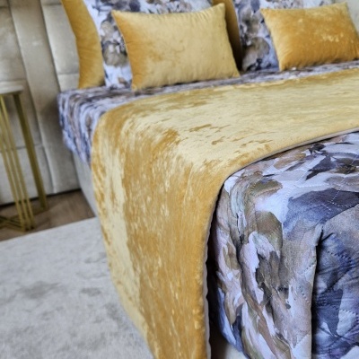 Cama com edredão floral azul e manta amarela de veludo