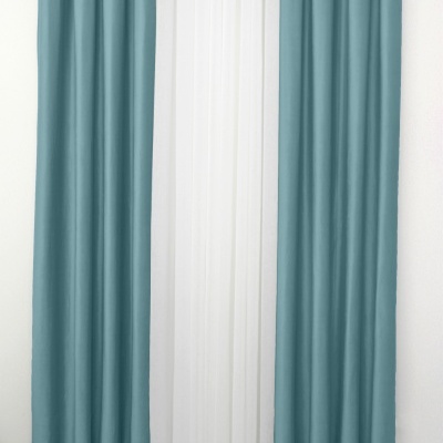 Conjunto de cortinados azuis turquesa e branco pendurados numa barra metálica simples