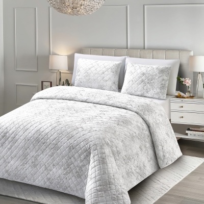 Cama com conjunto de edredão branco com padrão quadrado, almofadas e cabeceira estofada