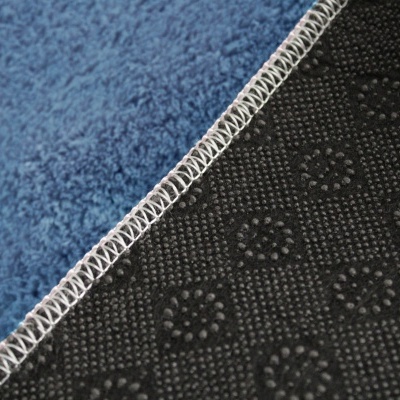 Tapete azul com verso antiderrapante preto com padrão e costura branca