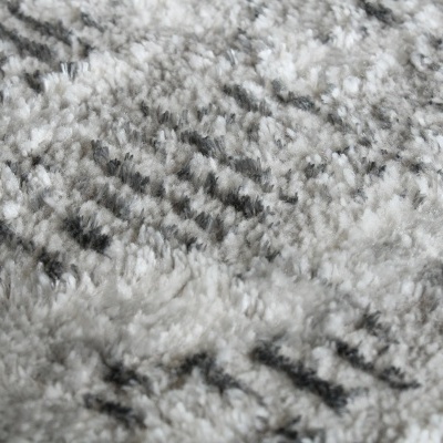Tapete felpudo cinza e branco com padrão abstrato preto