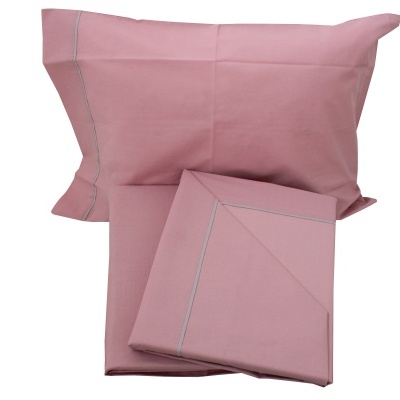 Conjunto de roupa de cama rosa com fronha e lençol em fundo branco