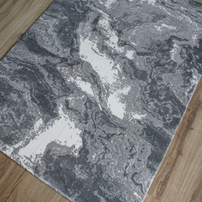 Tapete com padrão abstrato cinza e branco sobre chão de madeira clara