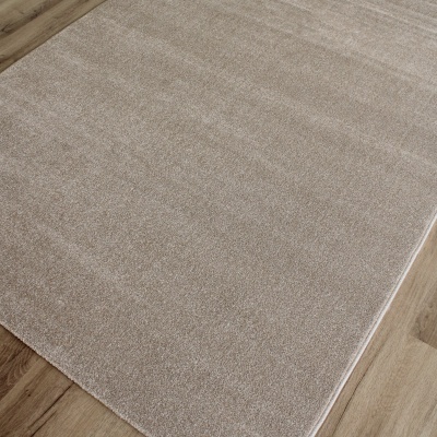 Tapete bege de pelo curto sobre chão de madeira clara