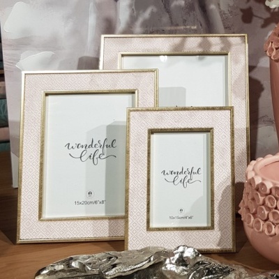 Três molduras de fotos bege com texto 'wonderful life' e vaso rosa decorativo