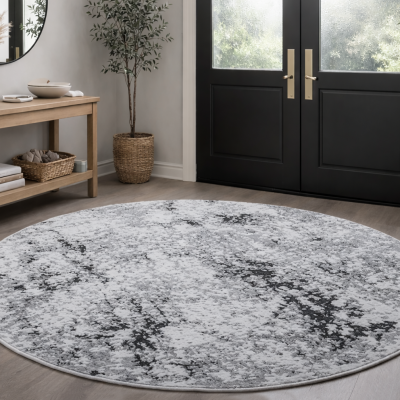 Tapete redondo cinza e branco com padrão abstrato em sala com mesa, plantas e porta preta