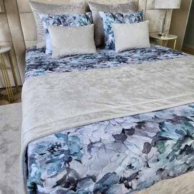 Cama elegante com roupa de cama floral e cinza aveludado numa decoração de quarto moderna