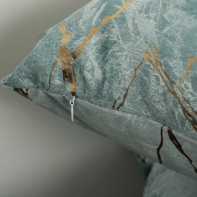 Travesseiro azul claro com padrão abstrato dourado e azul escuro e fecho branco