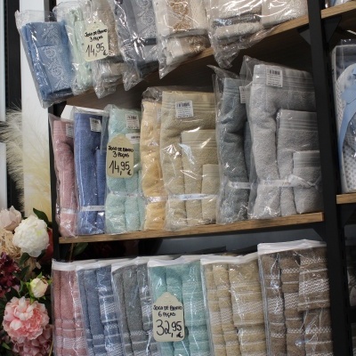 Conjuntos de toalhas de banho coloridas embaladas em plástico em prateleiras