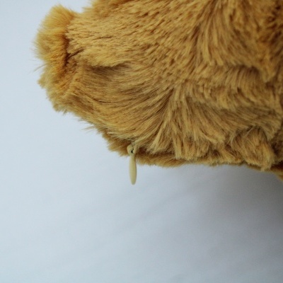 Pelúcia castanha com pelo longo e dente branco