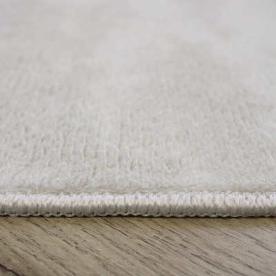 Tapete creme claro macio sobre piso de madeira clara