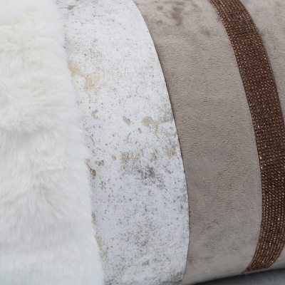 Três almofadas decorativas em tons bege e branco com texturas variadas