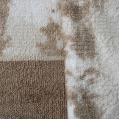 Tapete ou manta bege e castanho com padrão geométrico e textura felpuda