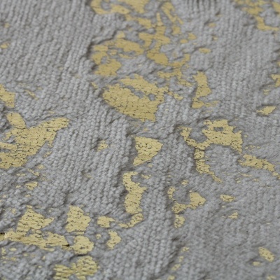 Tecido cinzento com padrão dourado irregular e textura em relevo