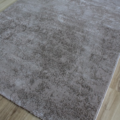 Tapete cinzento com padrão abstrato sobre chão de madeira clara