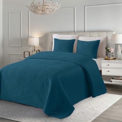 Cama com colcha e almofadas azuis com padrão ondulado em quarto moderno