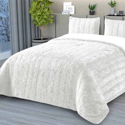 Colcha e almofadas brancas com textura rugosa em cama de madeira clara