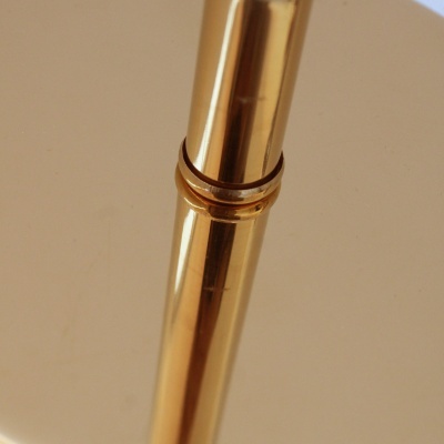 Estrutura metálica dourada com acabamento brilhante e disco circular