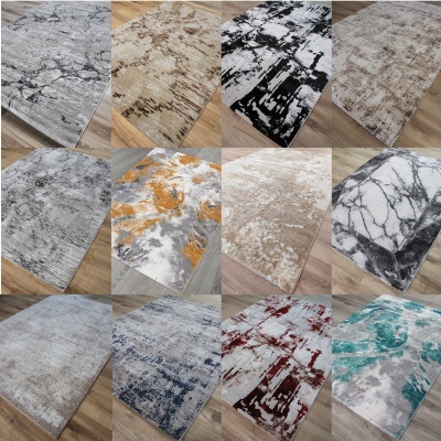 Doze tapetes coloridos com padrões abstratos sobre chão de madeira clara