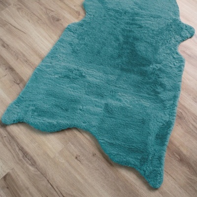 Tapete azul turquesa felpudo em chão de madeira clara
