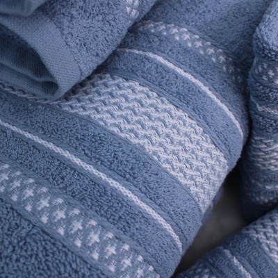 Toalhas azuis com padrões texturizados e riscas horizontais em tecido de banho