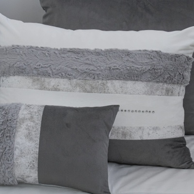 Duas almofadas decorativas cinza e branco com texturas variadas e detalhes brilhantes.