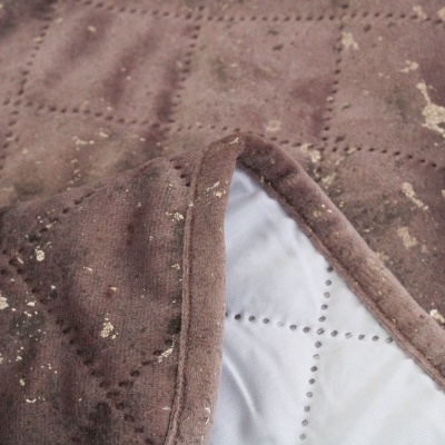 Manta castanha acolchoada com manchas e forro branco acolchoado