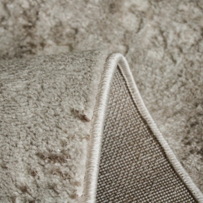 Tapete bege de tecido com textura macia e borda costurada